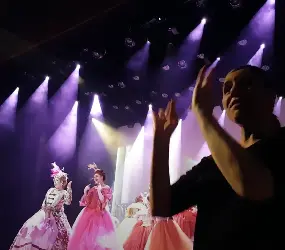 Cena no teatro a Cinderela, com atrizes ao fundo e a intérprete de Libras á frente